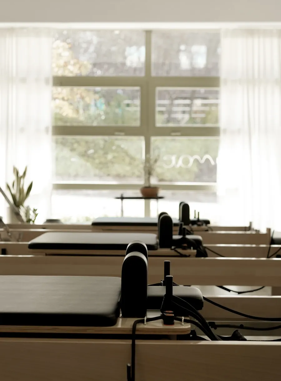 Sala de MOVE Pilates Boutique en Pozuelo de Alarcón con reformers de madera y luz natural del ventanal